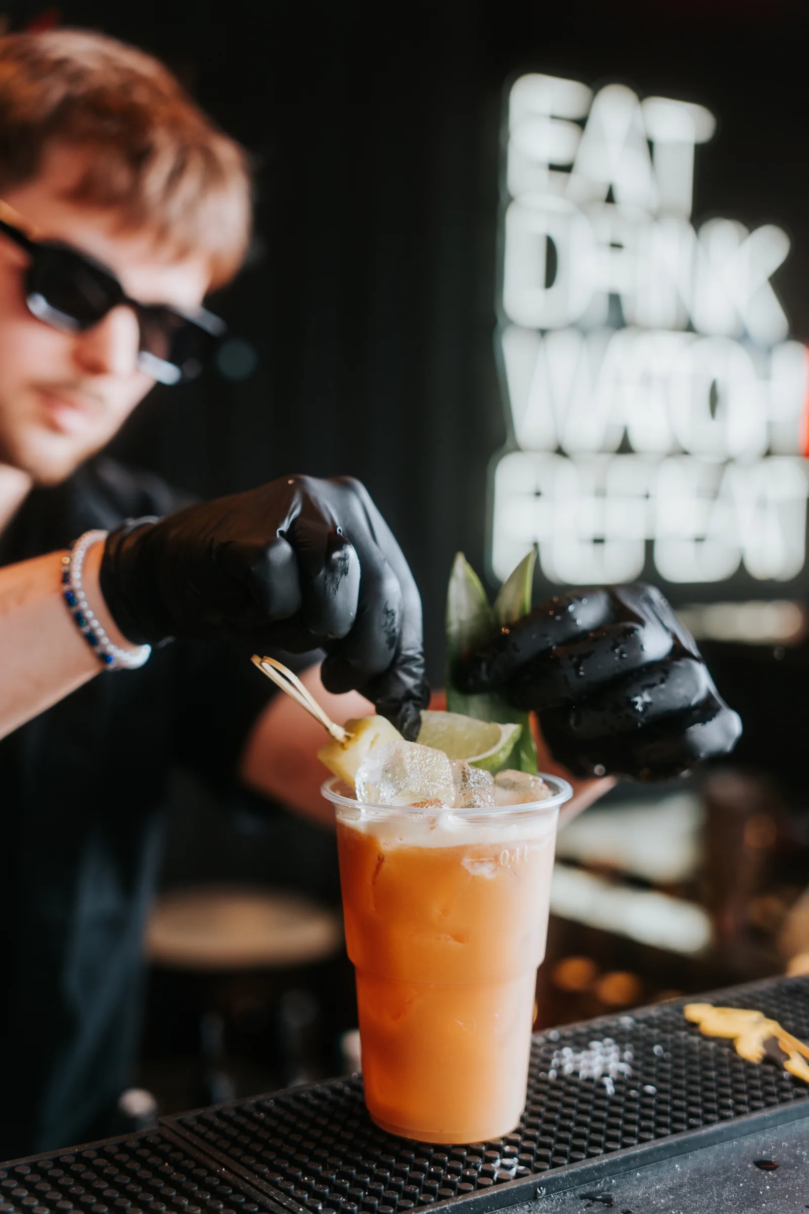 Barman przygotowujący letni koktajl w Pitlane Summer Bar