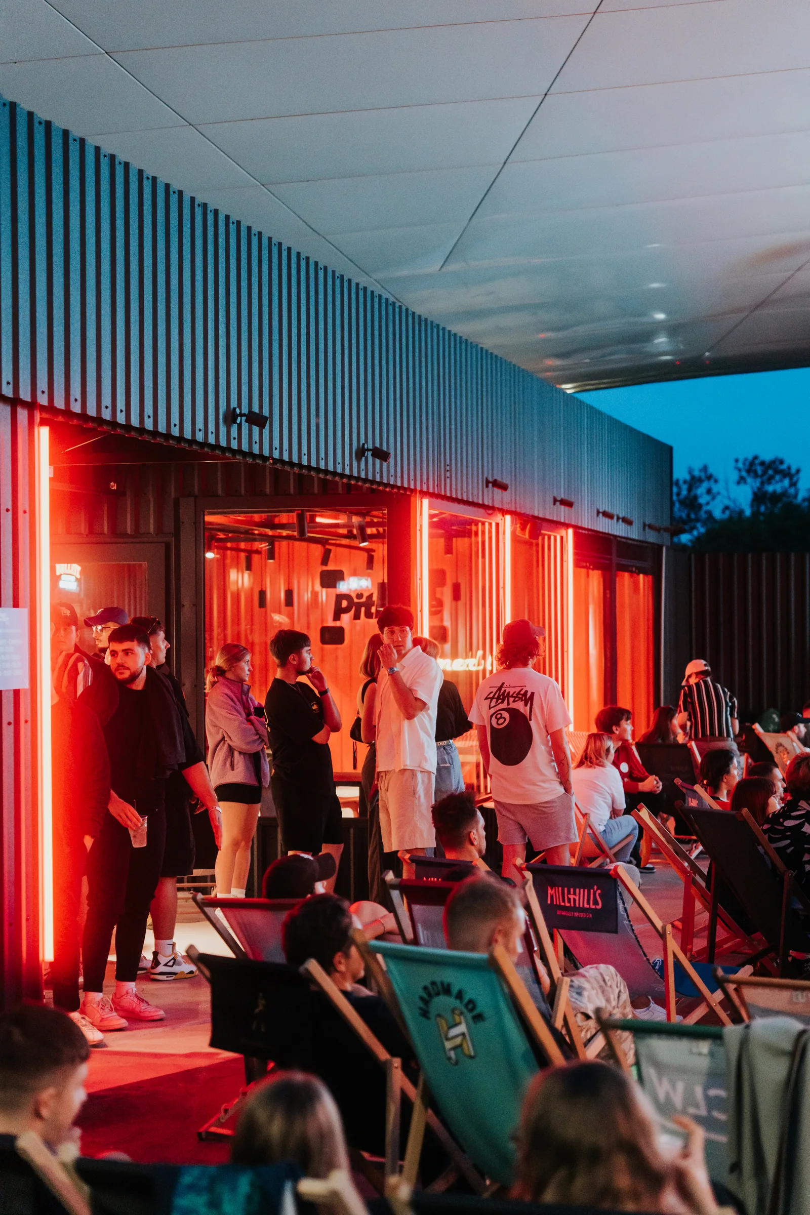 Wieczorne wejście do Pitlane Summer Bar w czerwonym świetle
