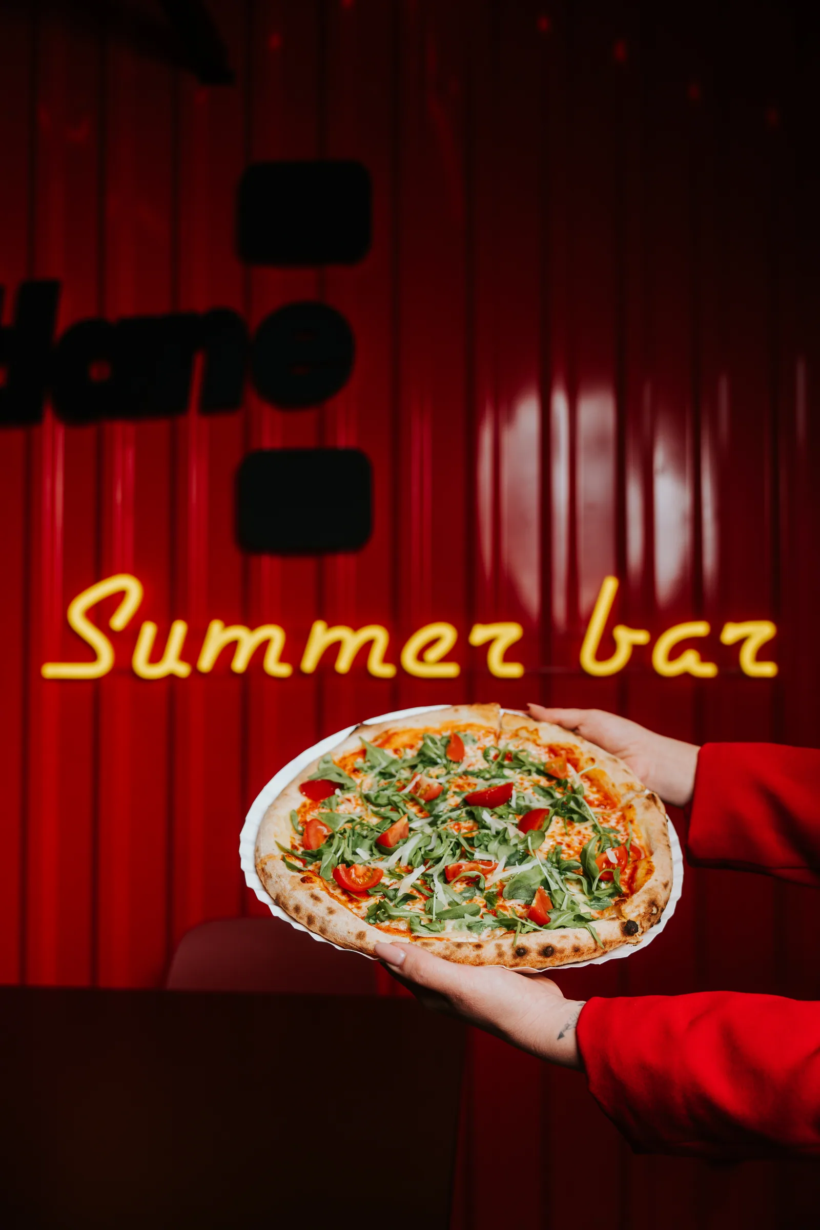 Pizza na tle neonowego napisu Summer Bar w Pitlane